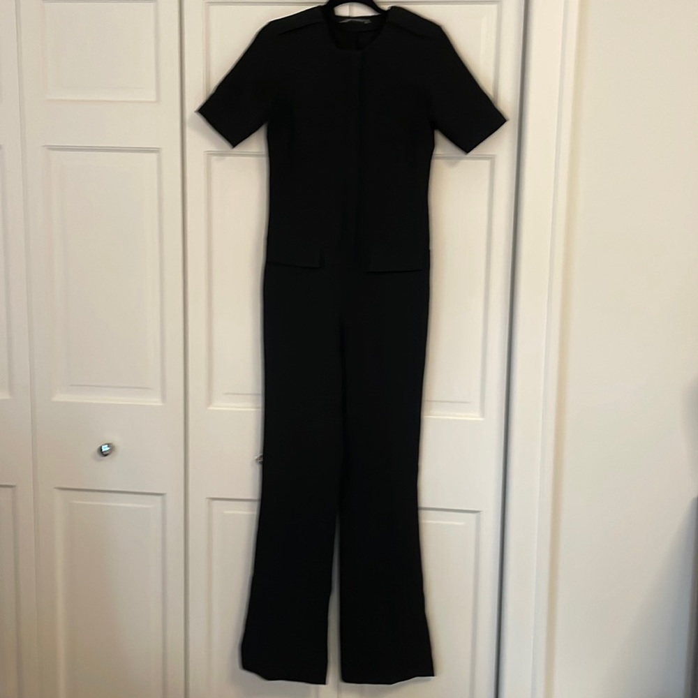 Black polyester knit jumpsuit with faux epilate & pocket detail